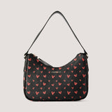 Scattered heart print shoulder bag with a curved shape.